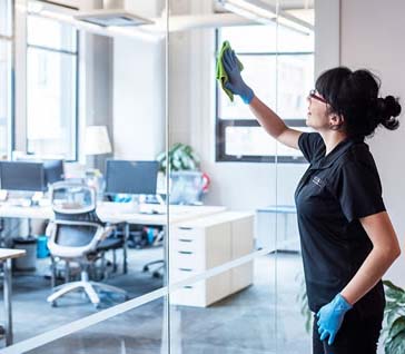 image of woman wiping a glass partition